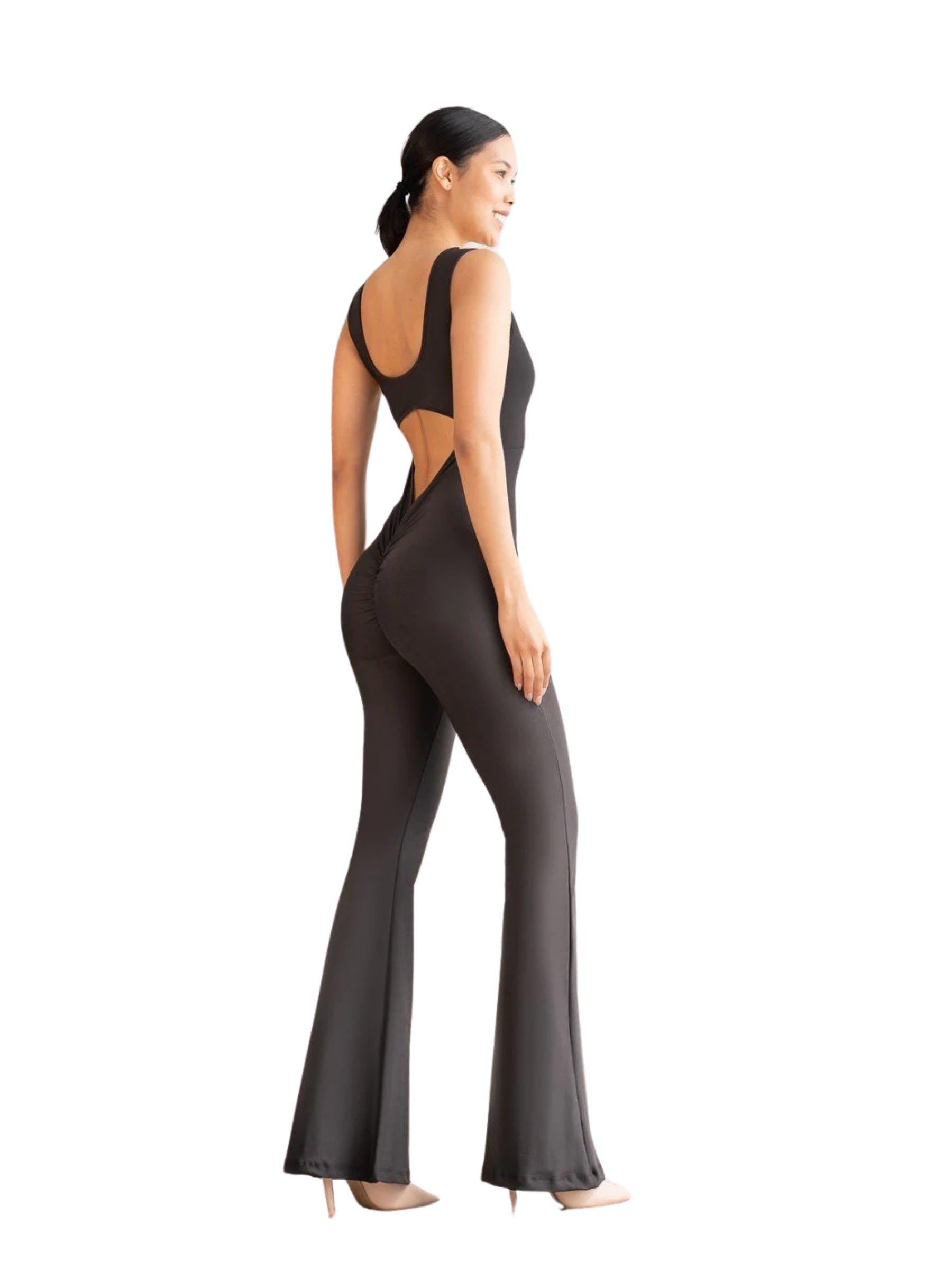 Frau in Lisminas 1500 Spanish Scrunch Butt Jumpsuit in Schwarz, von der Seite gesehen auf weißem Hintergrund.